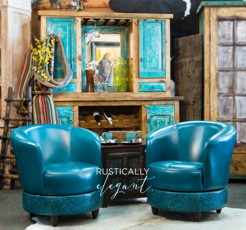 Two turquoise leather lounge chairs in front of a wooden turquoise blue hutch